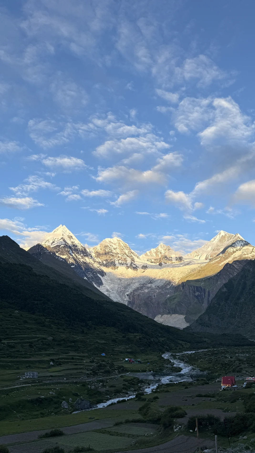 Sunlit peaks and a river through a mountain valley